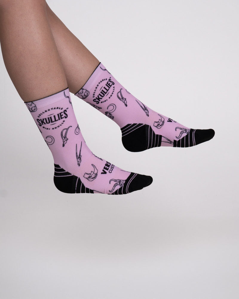 Load image into Gallery viewer, Pink Skullies crew socks with black African wildlife skull print and Skullies logo, side view

